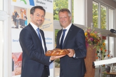 Landrat Oliver Stolz (rechts) übergibt symbolisch einen großen Schlüssel aus Kuchen an Erik Sachse